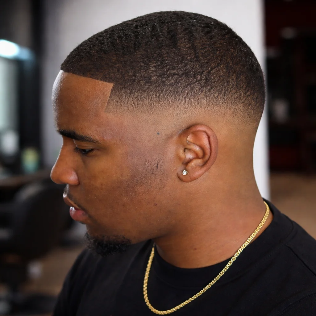 Potongan rambut low fade untuk lelaki kulit hitam dengan 360 waves, garis lineup yang tajam, dan sisi taper yang kemas dalam gaya barbershop moden.